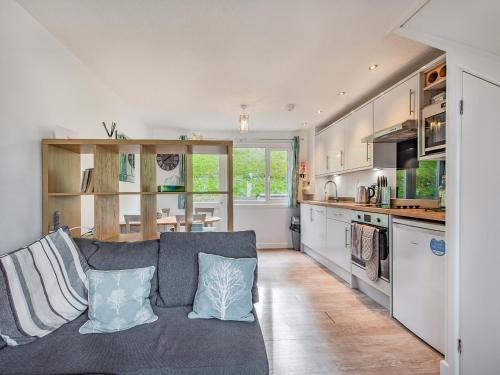 a living room with a gray couch and a kitchen at Uk41506 - Sunnybank in Hodgeston