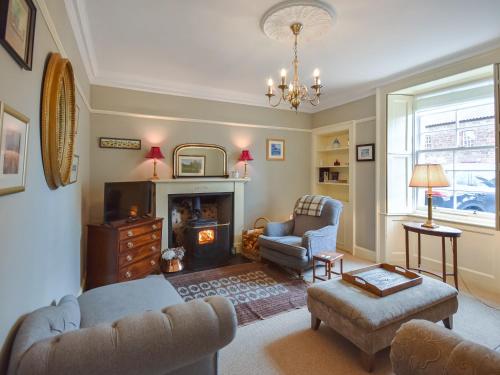 a living room with two chairs and a fireplace at Rennie House in East Linton