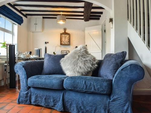 a dog sitting on a blue couch in a living room at Quay Cottage in Bewdley