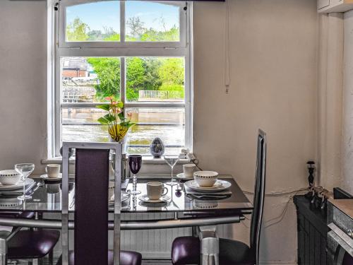 a dining room with a table and a window at Quay Cottage in Bewdley
