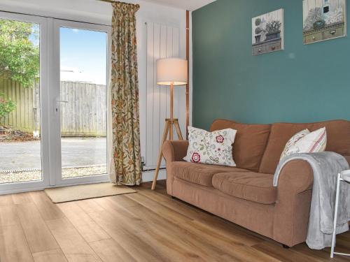 Una sala de estar con un sofá y una puerta corrediza de vidrio. en Little Fishes, en Ryde