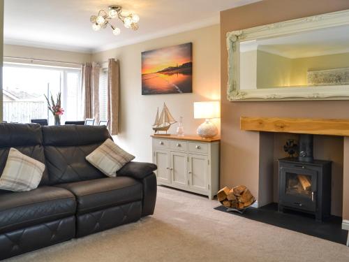 a living room with a couch and a fireplace at Oceans 44 in Sewerby