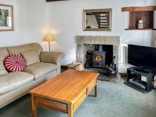 a living room with a couch and a fireplace at Butterfield Cottage in Tideswell