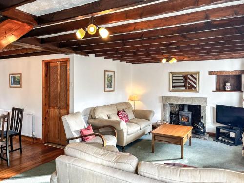 a living room with a couch and a fireplace at Butterfield Cottage in Tideswell