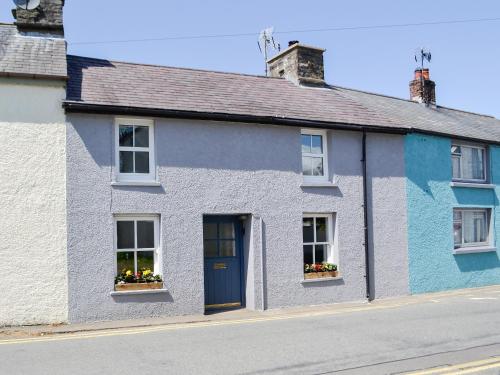 a blue and white house with flowers in windows at Troedyrhiw Isaf in Tregaron