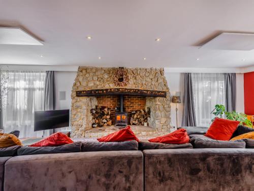 a living room with a large couch with a fireplace at Denmark House in Burham