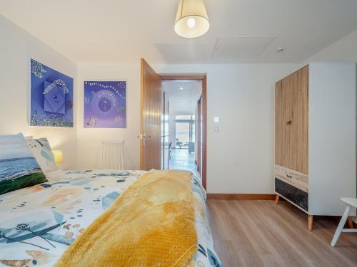 a bedroom with a large bed and a closet at Postbox Cottage in Catacol