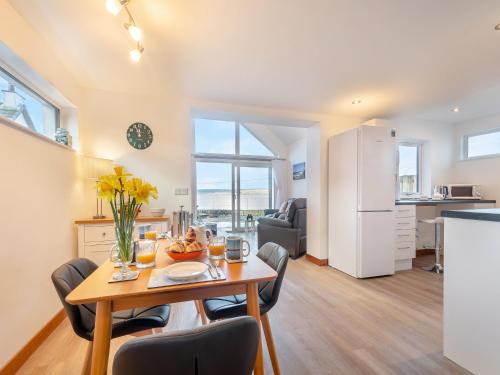 a kitchen and living room with a table and chairs at Postbox Cottage in Catacol