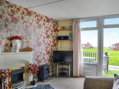 a living room with a fireplace and a tv at Yeolde Woodern Country View Seashak - Uk46596 in Bridlington