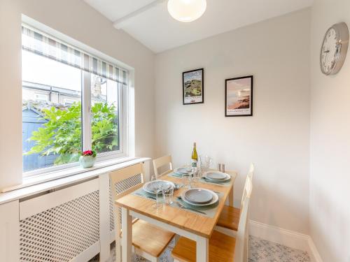 a dining room with a table and a window at Lundy Cottage in Alnwick