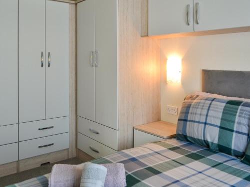 a small bedroom with a bed and white cabinets at Lodge 46 - Uk49669 in Bridlington