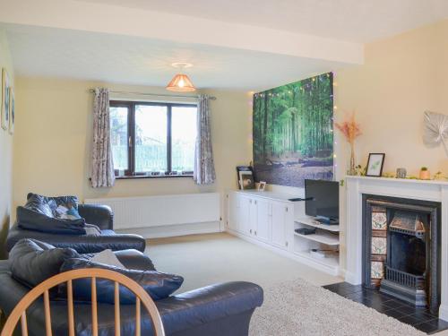 a living room with a couch and a fireplace at Farmers Cottage in Withernsea