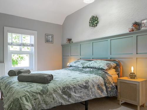 a bedroom with a bed with two pillows on it at Rose Cottage in Cromford