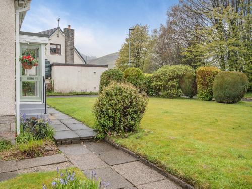 a yard with bushes and a house with a lawn at The Mulberry in Lamlash
