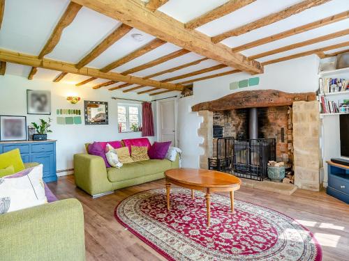 a living room with a couch and a table at Brookend Cottage - Uk49705 in Barton