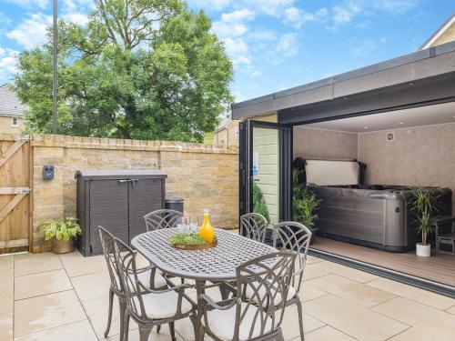 a patio with a table and chairs and a grill at High Peak Retreat in Buxton