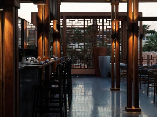 a restaurant with a bar with chairs and tables at The Chedi El Gouna in Hurghada