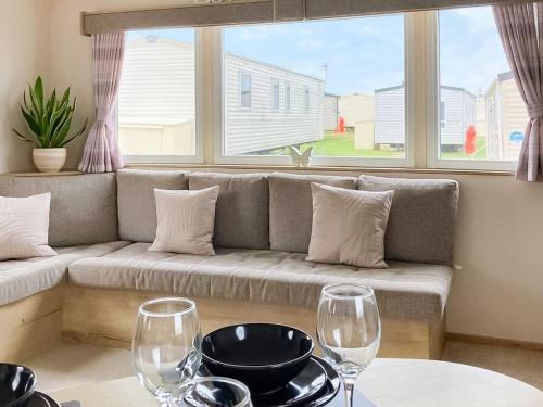 a living room with a couch and two wine glasses at Farne Lodge in Berwick-Upon-Tweed