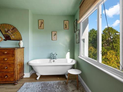 a bathroom with a white tub and a window at Chapter Meadow in Worcester