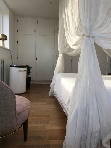a bedroom with a bed with a white canopy at Idyllic Cliffside Villa With Stunning Sea Views in Sandvig
