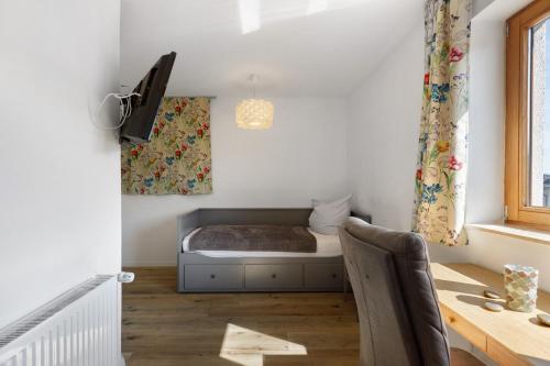 a small bedroom with a bed and a desk at Bergblick Apartments in Radolfzell am Bodensee