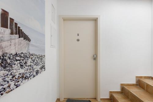 a hallway with a white door and a painting on the wall at Bergblick Apartments in Radolfzell am Bodensee