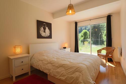 a bedroom with a bed and a large window at A5 - Résidence La Montille in Mont-Dore