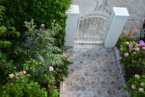 un giardino con una panchina bianca e alcuni fiori di Apartments Kaludjerovic a Herceg-Novi