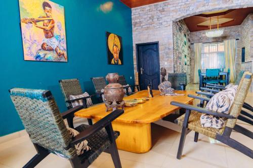 a dining room with a wooden table and chairs at Ibuye Villa Holiday Home in Nyakinama