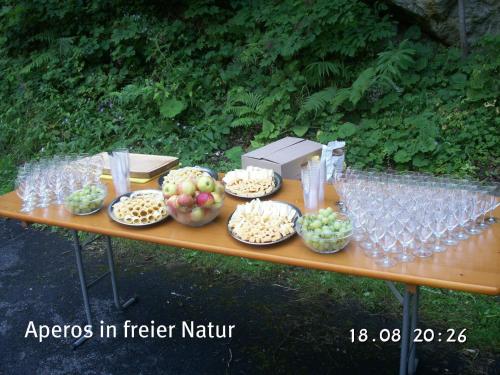 a table with bowls of fruit and wine glasses at Hotel-Restaurant Alpina in Innertkirchen