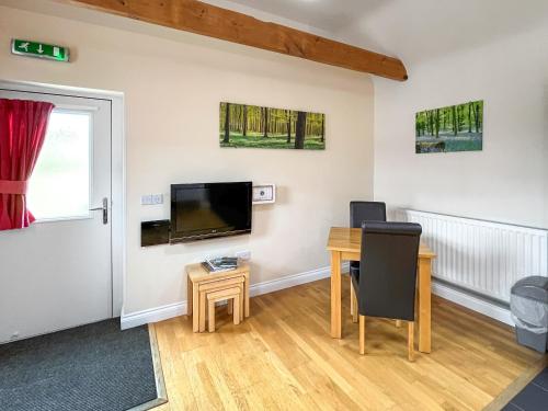 a living room with a table and a tv at Wendys Wing - Uk49742 in Fulletby