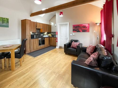 a living room with a black couch and a table at Wendys Wing - Uk49742 in Fulletby
