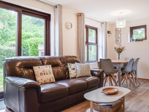 a living room with a leather couch and a table at Hey Ho Cottage in Whitby
