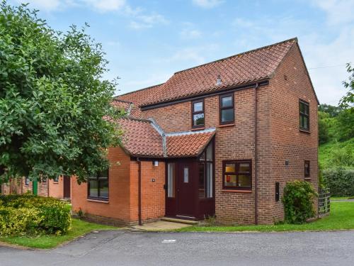 a red brick house with a red roof at Hey Ho Cottage in Whitby