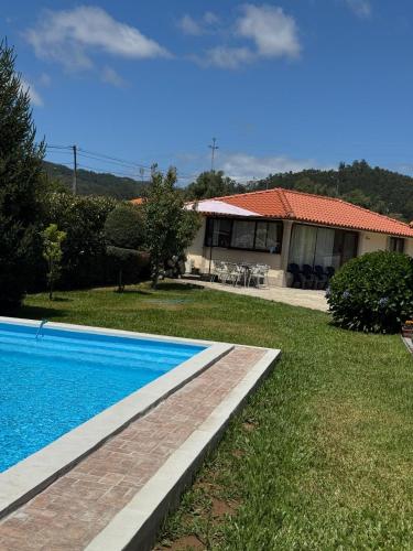 a house with a swimming pool in the yard at Oliveira's Little House in Caminha