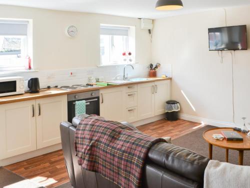 a living room with a couch and a kitchen at Swan's Nest - Uk43545 in Belford