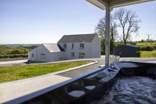 a bath tub with a sink in front of a house at Drefach - Refurbished farmhouse in stunning surroundings with hot tub in Llanwinio