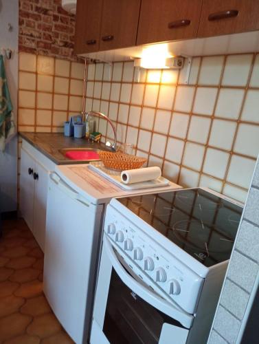 Il comprend une cuisine équipée d'une cuisinière et d'un lave-vaisselle blanc. dans l'établissement studio à 50 m de la plage , idéal pour 2, avec parking 2NOUMÉA35, à Canet