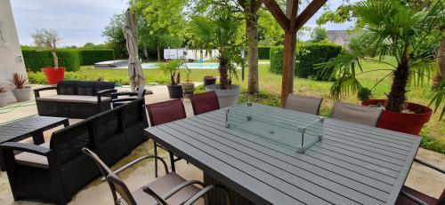 a picnic table with chairs and a table with a glass item on it at Les Randonneuses in Marcilly-sur-Seine