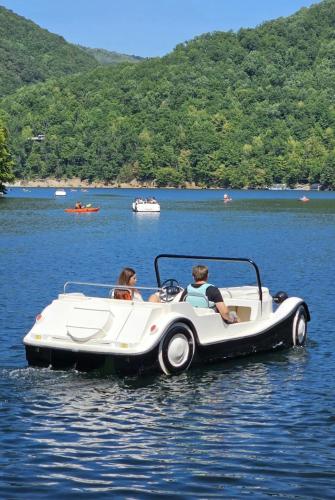 two people in a white boat in the water at Garsonierǎ la curte cu ciubǎr in Cluj-Napoca