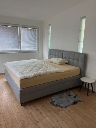 a bedroom with a bed and a table and windows at Vacation home Oxy in Ferlach