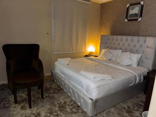 a bedroom with a large bed and a chair at el maqam el zahbe in Al Khansāk