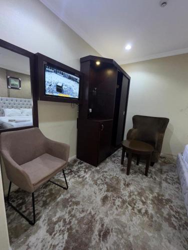 a room with a bed and a chair and a tv at el maqam el zahbe in Al Khansāk
