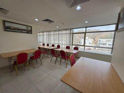 a conference room with tables and chairs and windows at el maqam el zahbe in Al Khansāk