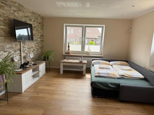 a bedroom with a bed and a television in it at Pension Sonnenstrand in Norden