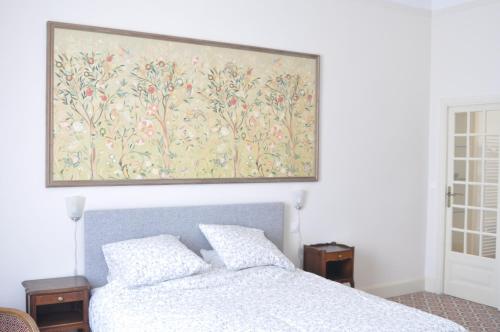 a bedroom with a bed with a painting on the wall at Relais des Vignerons, Chambres d'hôtes in Conilhac-Corbières
