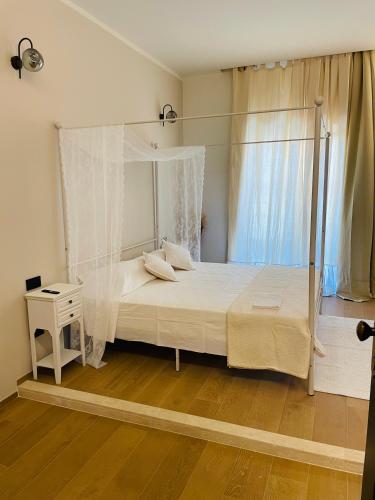 a bedroom with a canopy bed and a wooden floor at Le Boulevard Suites & Apartments in Olbia