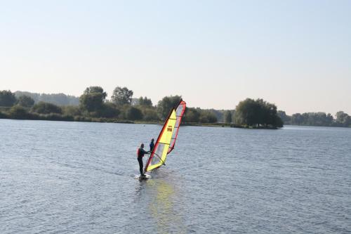 a man is windsurfing on a body of water at Alivio - Thuiskomen bij jezelf op vakantie in Lummen