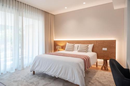 a bedroom with a bed and a large window at Casa Atlântica 26 in Troia