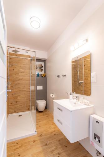 a bathroom with a shower and a sink and a toilet at APARTAMENT NADMORSKI in Rowy